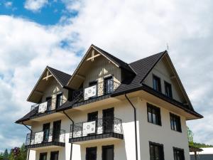 a white building with a black roof at Siedlisko Szlachtowskie in Szczawnica