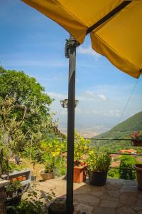 a yellow umbrella sitting on a patio with plants at La Valle degli Orti in La Spezia