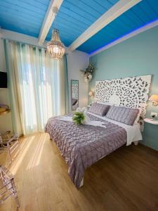 a bedroom with a large bed and a blue ceiling at Fior dei Carmeliti Rooms and Parking in Tropea
