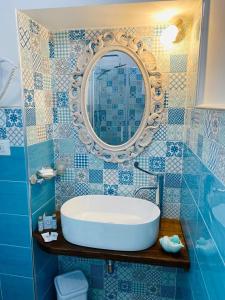 a bathroom with a tub and a mirror on the wall at Fior dei Carmeliti Rooms and Parking in Tropea