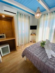a bedroom with a bed with a purple comforter at Fior dei Carmeliti Rooms and Parking in Tropea