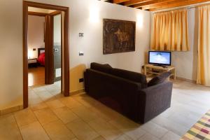 a living room with a couch and a television at La Casa del Nonno in Monzambano