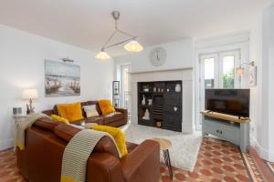 een woonkamer met een bank en een televisie bij Charles Alexander Short Stay - Clifton Drive Beach Retreat in Saint Annes on the Sea