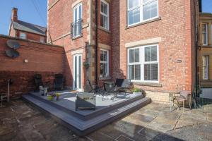 a patio in front of a brick building at Charles Alexander Short Stay - Clifton Drive Beach Retreat in Lytham St Annes