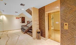 a lobby with a staircase and a glass door at Treebo Tryst Arista in Chandīgarh