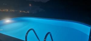 Olhares do Douro في Foz do Sabor: مسبح ازرق في الليل مع اناره