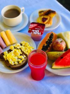 a table with plates of breakfast foods and a cup of coffee at Pousada Casa Do Mar in Paraty