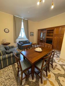 Intero appartamento 3 letti con garage gratuito في ليفورنو: غرفة معيشة مع طاولة وكراسي خشبية