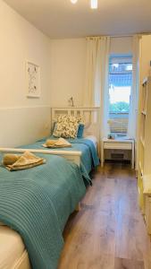 a bedroom with two beds and a window at FEWO II Villa Nicole Hafenstraße 37 in Zingst