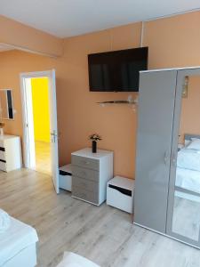 Habitación con cama y TV en la pared. en Gazi en Popovo