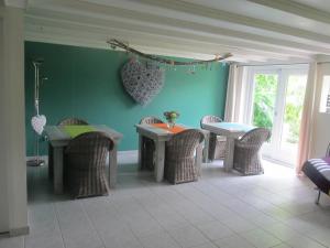 a dining room with tables and chairs and a green wall at Roing B&B in Hijken