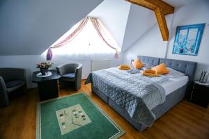 a bedroom with a bed and a chair and a window at Villa Nadmorska Łeba Centrum in Łeba