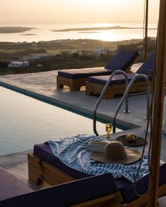 a swimming pool with two beds on the deck of a house at Sun House Paros in Kampos Paros
