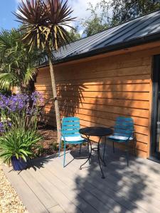 two chairs and a table on a deck at The Potting Shed in St Austell