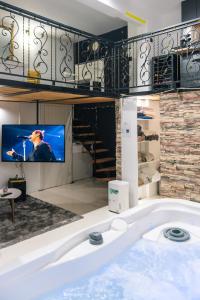 eine große Badewanne mit einem TV in einem Zimmer in der Unterkunft Deluxe dreams & spa Sabac in Šabac