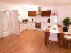 Una cocina con una mesa de madera y gabinetes blancos. en Wellness & Naturstrand (in 800 m), inkl. Pool, en Hof Barendorf
