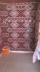 a bathroom with a wall with a red and white pattern at Qais Camp Wadi Rum in Wadi Rum