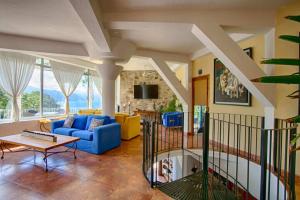 a living room with a blue couch and a table at Adventure House Conchas Chinas in Puerto Vallarta