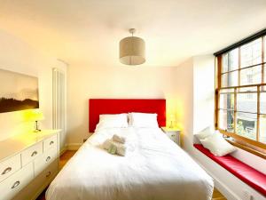 una camera da letto con un letto grande con testiera rossa di Prime Edinburgh New Town. Newly reno'd cosy nest a Edimburgo
