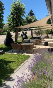 - un groupe de chaises et de parasols dans un parc dans l'établissement Doubs Hotel - Besançon Ecole Valentin, à Besançon