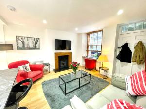 a living room with a red couch and a fireplace at Prime Edinburgh New Town. Newly reno'd cosy nest in Edinburgh