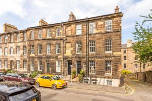 an old brick building with cars parked in front of it at Prime Edinburgh New Town. Newly reno'd cosy nest in Edinburgh