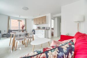 a living room with a red couch and a table at Apartament 2000 Stare Miasto bulwary Apartamenty No 1 in Szczecin