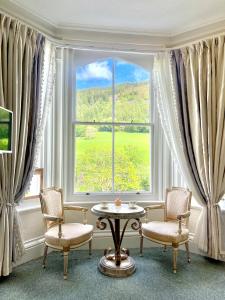 a room with a table and chairs and a large window at The Buckley Arms in Dinas Mawddwy