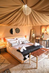 una camera con un grande letto in una tenda di Selina Agafay Nomad Camp a El Karia