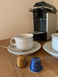 a table with plates and cups and a coffee maker at Blackforest Homestay in Herrischried