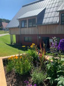 um jardim em frente a uma casa com flores em Blackforest Homestay em Herrischried