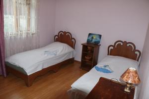 a bedroom with two beds and a table with a lamp at Gayane & Khikar B&B in Chʼiva