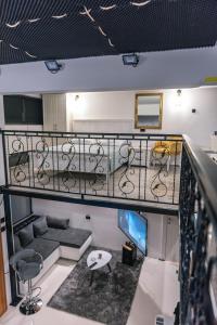 ein Zimmer mit einer Treppe mit einem Sofa und einem Tisch in der Unterkunft Deluxe dreams & spa Sabac in Šabac