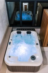 eine Whirlpool-Badewanne im Badezimmer mit zwei Spiegeln in der Unterkunft Deluxe dreams & spa Sabac in Šabac