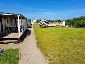 a large yard with a house and a playground at Mobilūs nameliai 'Zelma' in Palanga