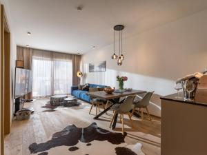 ein Wohnzimmer mit einem Tisch und einem blauen Sofa in der Unterkunft Apartment Liebelei am See - Kaiserblick, nah am Wasser und neuerbaut in Walchsee