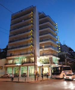 um edifício alto com um autocarro estacionado em frente em Balasca Hotel em Atenas