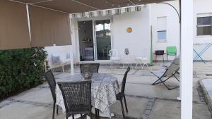 a patio with a table and chairs on a patio at Casa Mare Ognina in Ognina