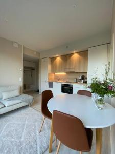 a kitchen with a white table and chairs in a room at Skyview apartment Kalajoki Hiekkasärkät in Kalajoki