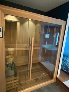 a glass cabinet in a room with a tub at Villa 96 Golf de la Baule avec piscine et spa in Saint-André-des-Eaux