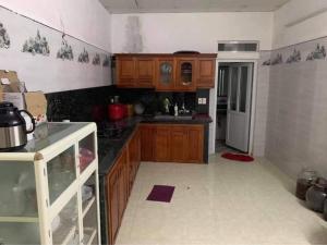 a kitchen with wooden cabinets and a refrigerator at Homestay hải tiến 25 in Thanh Hóa