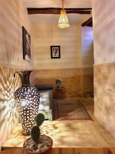 sala de estar con sofá y jarrón sobre una mesa en Riad Dar Zouar & Spa, en Marrakech