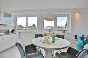 een keuken en eetkamer met een tafel en stoelen bij Appartemenhaus Linda-Lu Appartementhaus Linda-Lu Appartement 9 in Scharbeutz