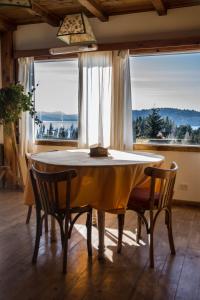 a dining room table with two chairs and a large window at Pajaro Azul in San Carlos de Bariloche +37 photos
