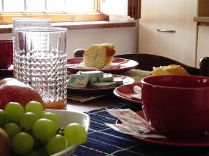 een tafel met druivenplaten en een glas water bij La casetta di Elsa in Cesiomaggiore