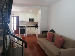 a living room with a couch and a kitchen at Casa Barrela II in Tavira