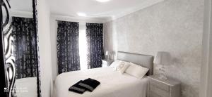 a bedroom with a white bed and a window at DUPLEX FUENGIROLA CENTRO 3 dormitorios in Fuengirola