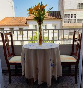 un vase de fleurs assis sur une table sur un balcon dans l'établissement Buen camino, à Saint-Jacques-de-Compostelle