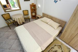 a bedroom with a bed and a table and chairs at Guest House Topla in Herceg-Novi