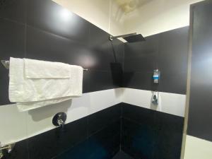 a black and white bathroom with a towel on the wall at Hotel Hibiscus in Bujumbura